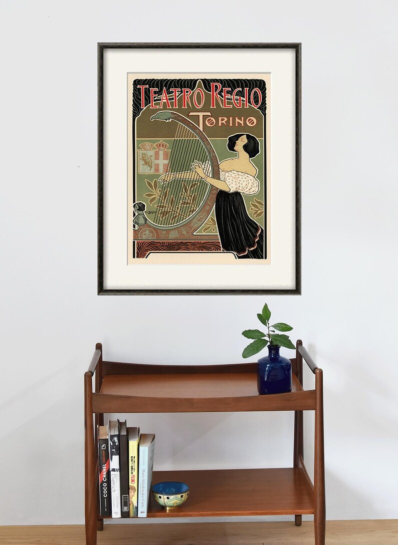 Peut inclure: Une affiche vintage annon&ccedil;ant l'op&eacute;ra Teatro Regio de Turin, en Italie. L'affiche repr&eacute;sente une femme jouant du harpe avec un blason en arri&egrave;re-plan. Le texte sur l'affiche indique "Teatro Regio Torino".