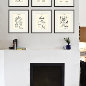 Puede incluir: Un conjunto de seis impresiones enmarcadas en negro de dibujos de patentes vintage relacionados con el golf. Las impresiones est&aacute;n dispuestas en una cuadr&iacute;cula en una pared blanca sobre una chimenea.