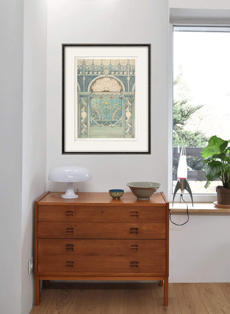 Peut inclure: Une estampe encadr&eacute;e d'un motif complexe et color&eacute; repr&eacute;sentant une plume de paon. Le motif est dans des tons de bleu, vert et or, et est plac&eacute; sur un fond blanc. Le cadre est noir et a un passe-partout blanc.