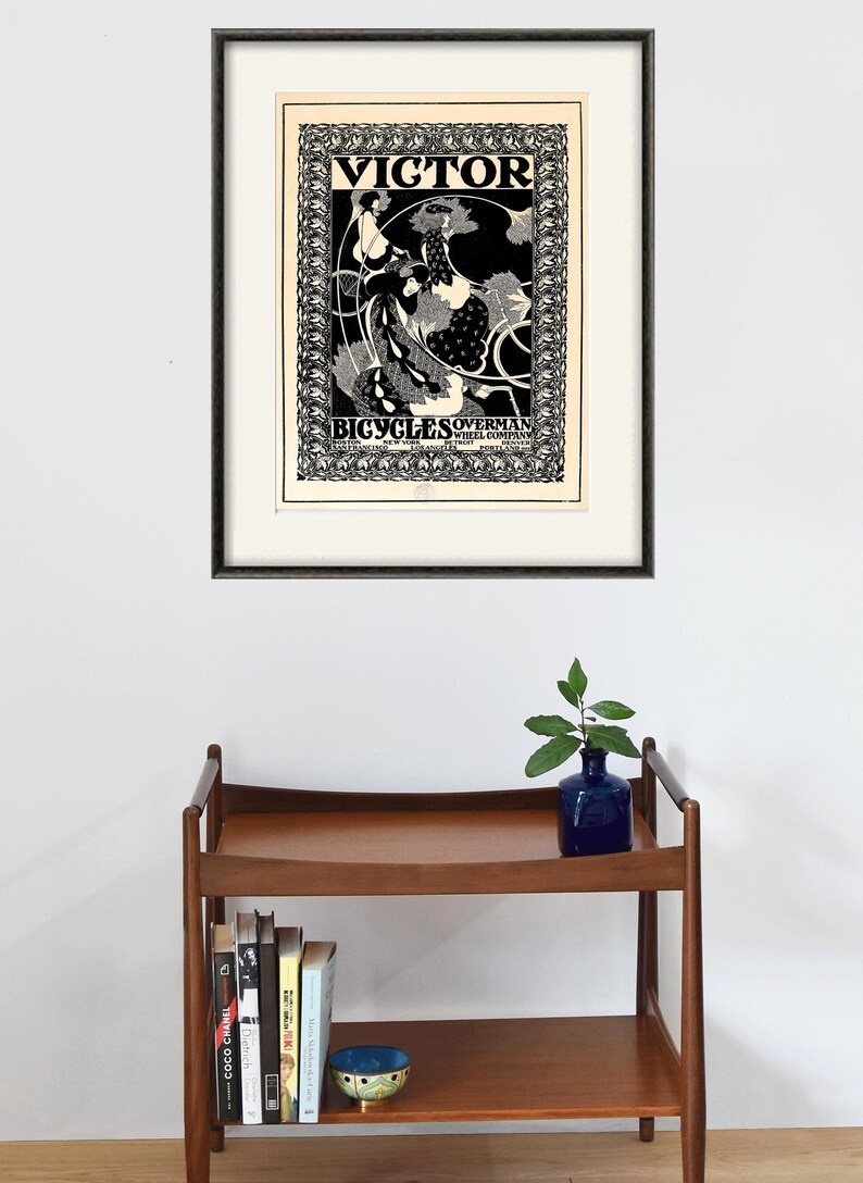 Pu&ograve; includere: Un poster vintage in bianco e nero che pubblicizza Victor Bicycles Overman Wheel Company. Il poster presenta una donna che guida una bicicletta con un design floreale decorativo.