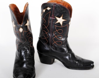 May include: A pair of black leather cowboy boots with white star and brown stitching detail.