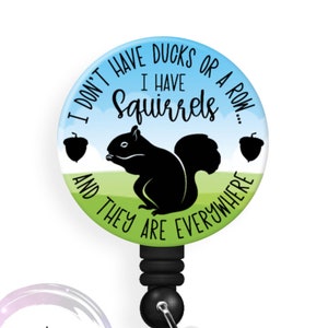 May include: A black and green badge reel with a round, colorful button featuring a silhouette of a squirrel and the text "I don't have ducks or a row... I have squirrels and they are everywhere".