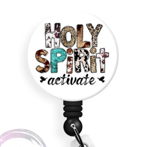 May include: A white badge reel with a round, white button featuring the text "HOLY SPIRIT activate" in black lettering with a variety of animal print patterns. The button is attached to a black retractable cord and a white clip.