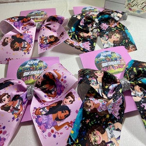 May include: Four purple and black hair bows with a silver glitter center. Each bow features a different image of a cartoon girl with the text "Happy Birthday Ariadne" on a purple card.