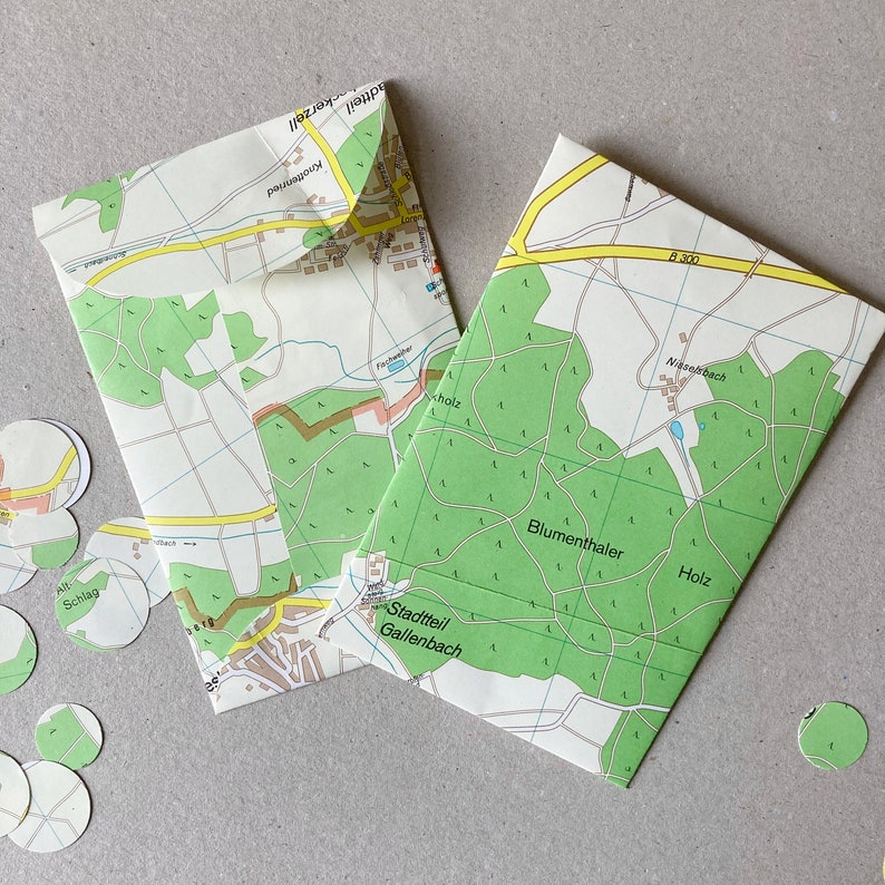 May include: Two folded maps with green and yellow markings. The maps are labeled with the names of different neighborhoods, including Blumenthaler, Holz, and Nisselbach.
