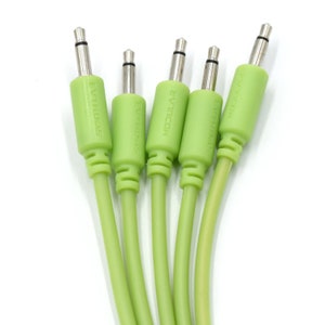 Peut inclure: Cinq câbles de patch verts avec des connecteurs argentés. Les câbles sont étiquetés "Modular", "Synth-Base", "EVH-FRIAS", "EVH-FRIAS" et "Modular".