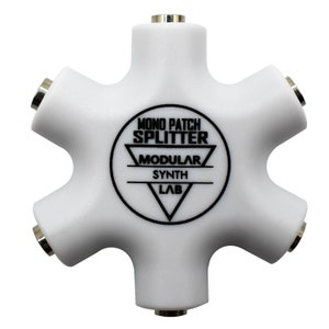 Op de afbeelding: Een witte 5-weg mono patch splitter van plastic met de tekst "MONO PATCH SPLITTER MODULAR SYNTH LAB" gedrukt op de voorkant.