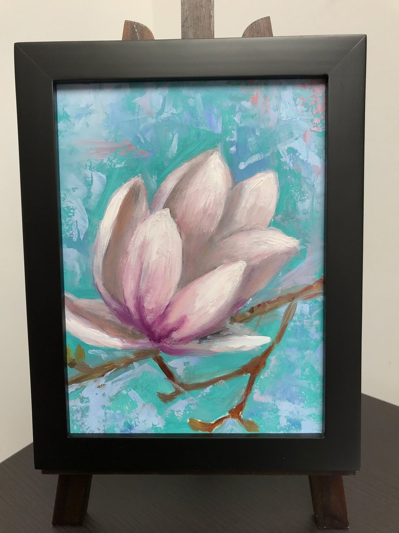 May include: A framed painting of a single pink magnolia flower with a light blue and green background.