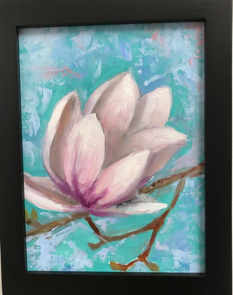 May include: A close-up of a single pink magnolia flower with a light blue background. The flower is in bloom and has a delicate, soft texture.