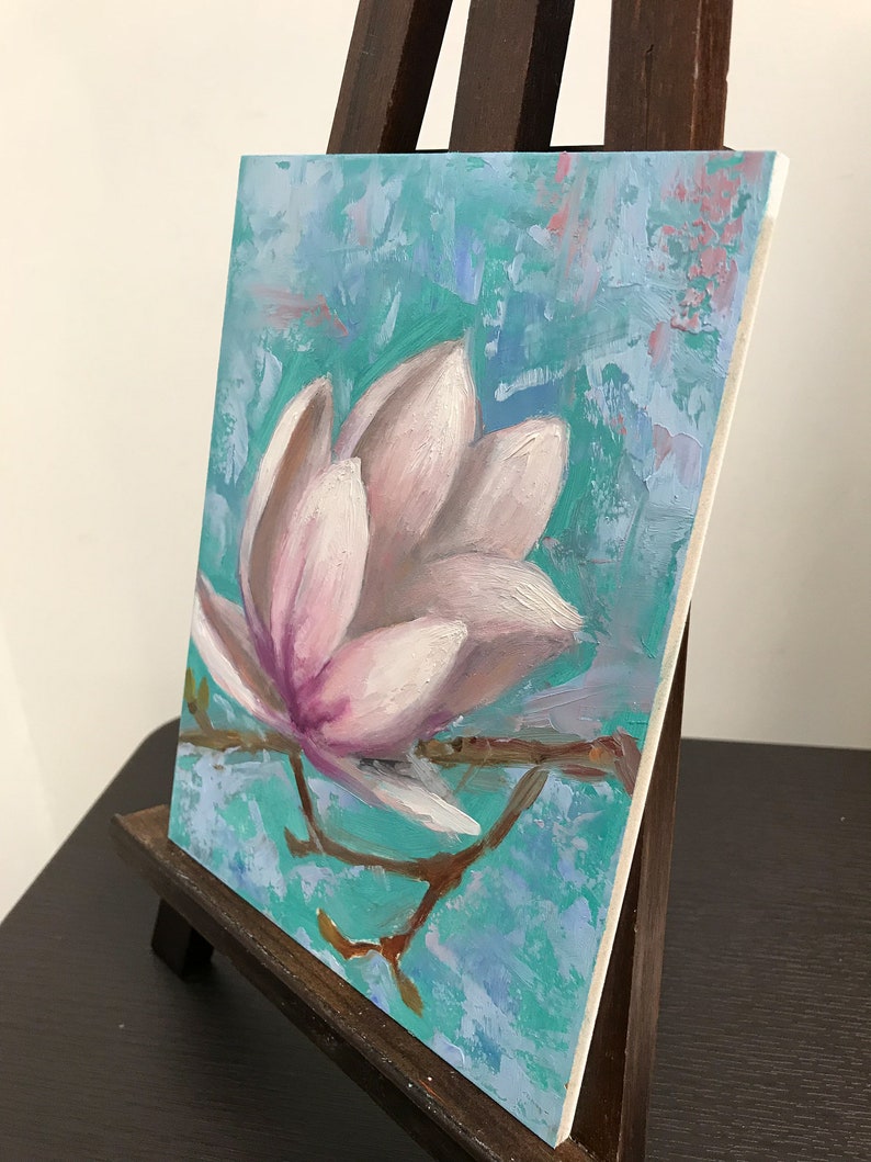 May include: A painting of a single pink magnolia flower on a branch against a turquoise blue background. The flower is painted in a realistic style with visible brushstrokes.