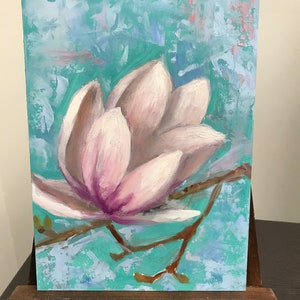 May include: A painting of a single pink magnolia flower with a light blue and green background.