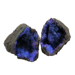 May include: Two halves of a geode with a dark grey exterior and a sparkly blue interior.