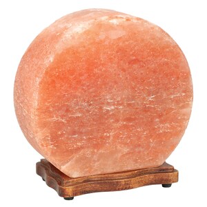 K&ouml;nnte beinhalten: Eine gro&szlig;e, runde Himalaya-Salzlampe mit einem nat&uuml;rlichen, orange-rosa Farbton. Die Lampe steht auf einem Holzsockel mit einem dekorativen Rand.