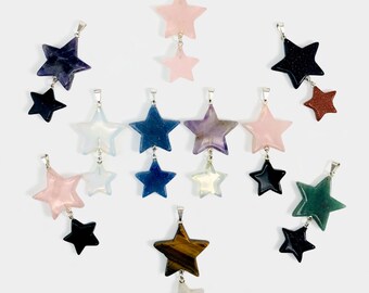 May include: A collection of 10 double star pendants made of various gemstones, including amethyst, rose quartz, tiger's eye, and green aventurine. Each pendant features a larger star charm with a smaller star charm dangling below.