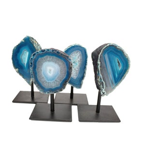 May include: Four blue agate slices on black metal stands. The agate slices have a white center and blue and white banding.