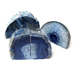 Op de afbeelding: Drie blauwe agaat boekenleggers. De boekenleggers zijn gemaakt van natuurlijke agaat en hebben een uniek, wervelend patroon. Ze zijn perfect om een ​​toets van natuurlijke schoonheid aan uw huis toe te voegen.