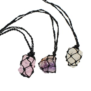 May include: Three crystal necklaces with different colored stones. Each stone is wrapped in a black macrame net and hangs from a black cord.