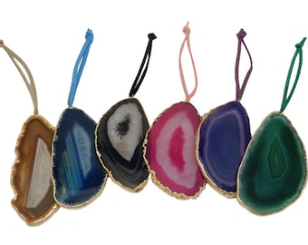 May include: Six agate slice ornaments with gold trim and colourful patterns. Each slice is attached to a string for hanging.