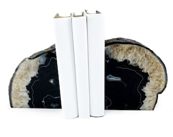 May include: A set of three white bookends shaped like a half-circle of black and brown agate.