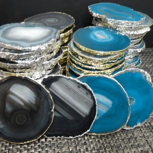 Puede incluir: Apilados de posavasos de ágata con bordes dorados plateados y dorados. Los posavasos presentan patrones naturales en tonos grises, negros y verde azulado. Estos posavasos decorativos añaden un toque de elegancia a cualquier hogar.