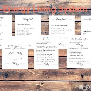 May include: A wooden background with the text "Low-Energy Living System" in orange. Several white cards with black text are arranged on the wood. The cards contain text and decorative leaf designs.