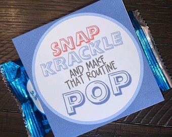 May include: A blue and white card with a circle in the center. The circle has the text "SNAP KRACKLE AND MAKE THAT ROUTINE POP" in red, blue, and white text.