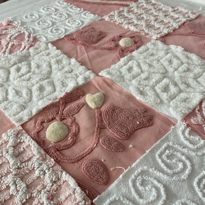 May include: A pink and white patchwork quilt with a variety of textures and patterns. The quilt is made of cotton fabric and has a soft, fluffy feel.