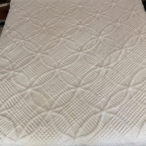 May include: White cotton bedspread with a diamond pattern and a ruffled edge.