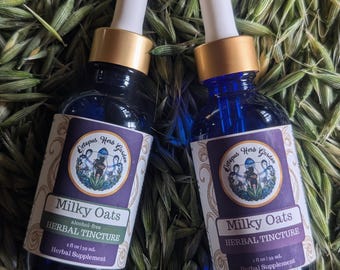 May include: Two blue glass bottles of "Milky Oats Herbal Tincture" with white and purple labels. The labels feature the text "Octopus Herb Garden" and a botanical illustration. Each bottle contains 59 ml of liquid.