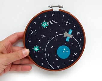 Space #35 embroidery hoop art with a planet and satellite orbiting around it
