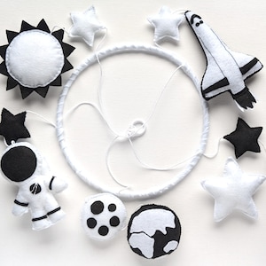 Black & white space-themed baby crib mobile with an astronaut and Space Shuttle, handmade from felt