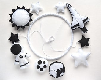 Black & white space-themed baby crib mobile with an astronaut and Space Shuttle, handmade from felt