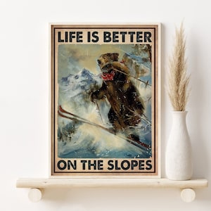 Puede incluir: Un póster de estilo vintage con un oso marrón esquiando por una montaña nevada. El póster tiene el texto "Life is better on the slopes".
