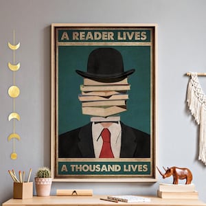 May include: Framed art print depicting a figure with a bowler hat and a stack of books for a face, wearing a suit and red tie. The text reads "A READER LIVES" at the top and "A THOUSAND LIVES" at the bottom, set against a teal background.