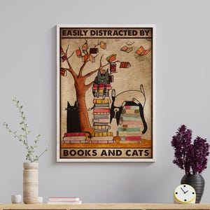 May include: A vintage-style poster with a brown background featuring a tree with books falling from its branches. Two black cats are sitting on stacks of books. The text reads "Easily Distracted By Books And Cats".