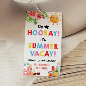 May include: A rectangular gift tag with the text "Sip sip HOORAY! It's SUMMER VACAY!" in colourful letters. The tag features a cartoon sun, tropical flowers, a flamingo, and other summer-themed illustrations. The tag is attached to a white string.