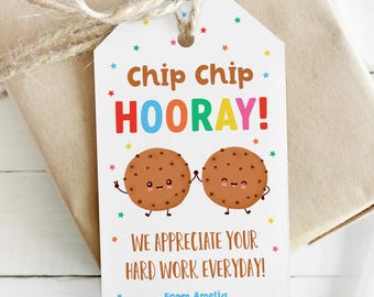 Może przedstawiać: Etykieta prezentu z napisem "chip chip HOORAY!" w kolorowych literach, z dwoma uśmiechniętymi ciasteczkami z kreskówek. Na etykiecie widnieje również napis "WE APPRECIATE YOUR HARD WORK EVERYDAY!" i jest ona przymocowana do zapakowanego prezentu sznurkiem.