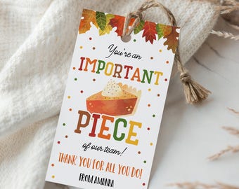 May include: A white gift tag with a pie graphic and the text "You're an IMPORTANT PIECE of our team! THANK YOU FOR ALL YOU DO! FROM AMANDA". The tag is tied with a natural twine string and decorated with fall leaves.