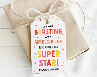 May include: A white rectangular gift tag with rounded top corners, featuring the colourful text "We are BURSTING with APPRECIATION THANK YOU FOR BEING A SUPER STAR! FROM ABC COMPANY" surrounded by small red, orange, pink, and yellow star icons.