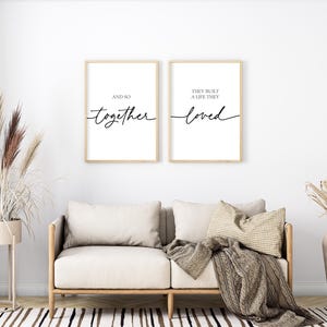 May include: Two framed prints with black calligraphy on a white background. The left print says "And so together". The right print says "They built a life they loved".