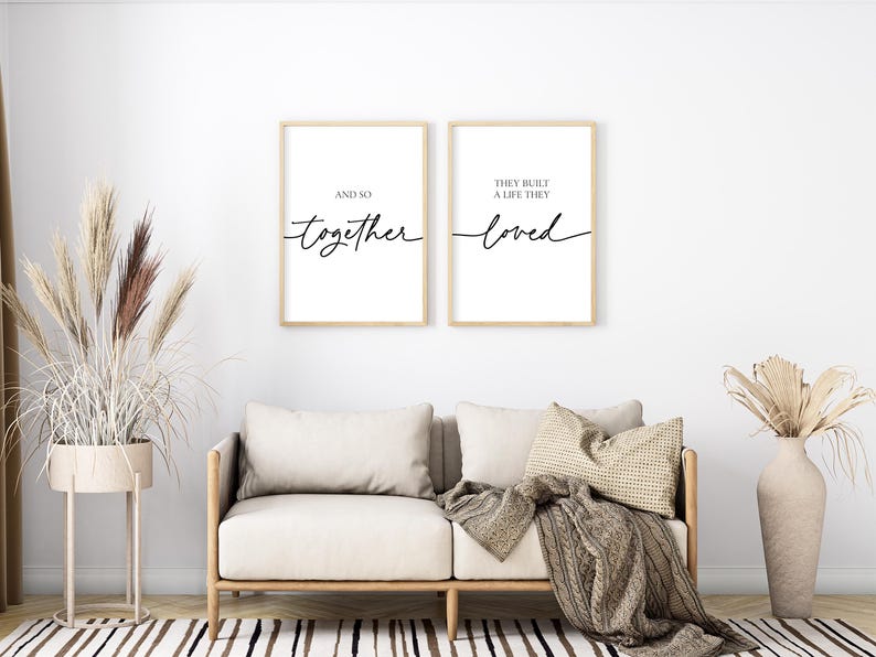 May include: Two framed prints with black calligraphy on a white background. The left print says "And so together". The right print says "They built a life they loved".