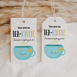 May include: Two white gift tags with blue and yellow teacup illustrations. The text on the tags reads "You are so TEA-RIFFIC Thanks for everything you do!"