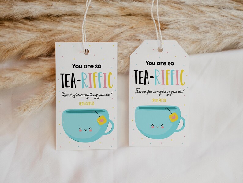 May include: Two white gift tags with blue and yellow teacup illustrations. The text on the tags reads "You are so TEA-RIFFIC Thanks for everything you do!"