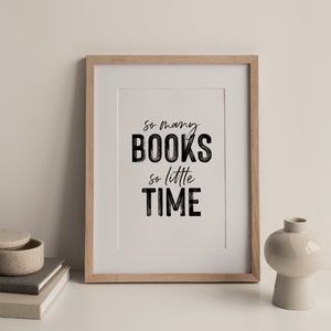 May include: A framed print with the text "So many books, so little time" in black lettering on a white background. The frame is light wood.