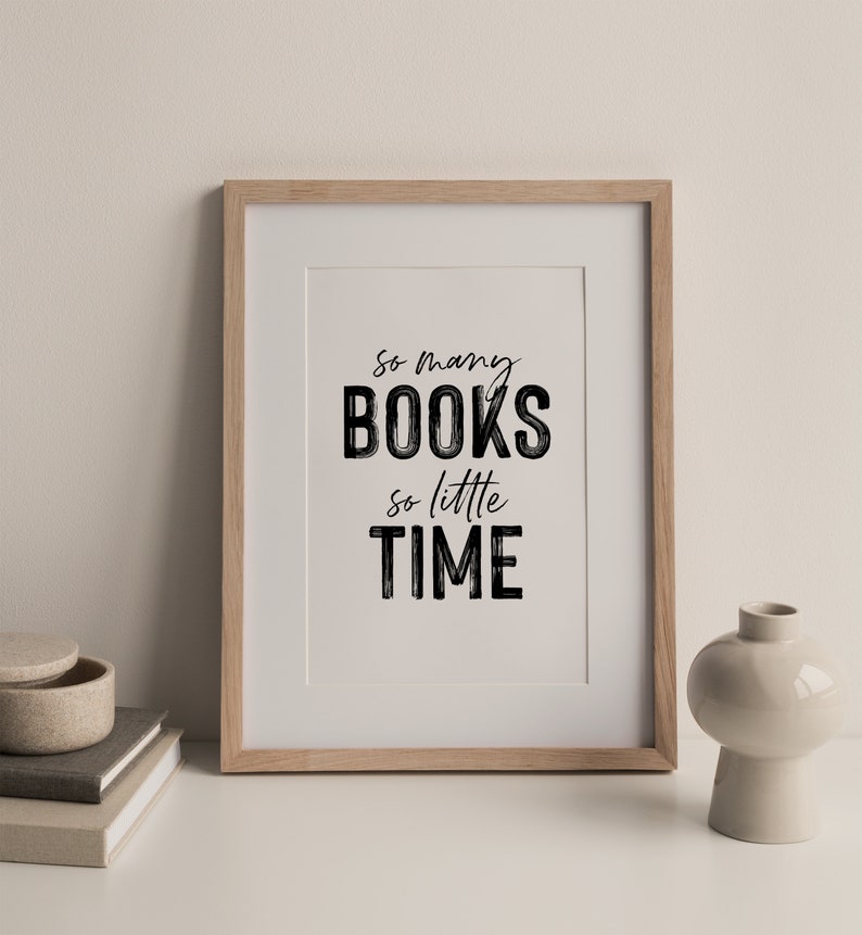May include: A framed print with the text "So many books, so little time" in black lettering on a white background. The frame is light wood.