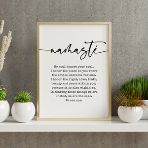 May include: A black and white printable wall art print with a gold frame. The print features the word "namaste" in a cursive font and a quote about honoring the soul. The quote reads: "My soul honors your soul. I honor the place in you where the entire universe resides. I honor the light, love, truth, beauty and peace within you, because it is also within me. In sharing these things we are united, we are the same. We are one."