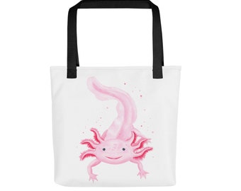 May include: A white tote bag with black handles features a pink axolotl with a smiling face. The axolotl is surrounded by small pink dots.