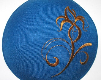 May include: A blue kippah with a gold embroidered floral design.