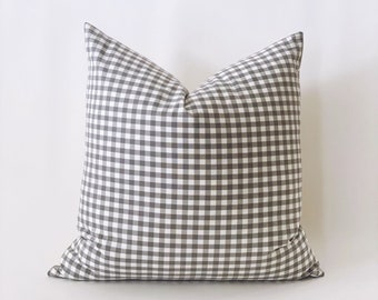 May include: A gray and white gingham pillow cover. The pillow cover is made of a soft, woven fabric and has a subtle sheen.