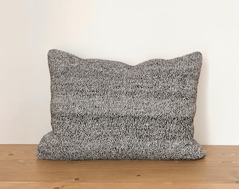 May include: A black and white patterned throw pillow with a rectangular shape.